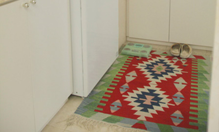 洗濯機の前にも絨毯を敷き、白っぽい空間をカラフルに演出