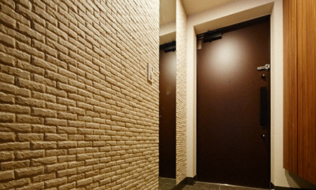 オプションで頼んだ石積み風のタイルと天井まである鏡が、ホテルのようなモダンな空間を演出している玄関。