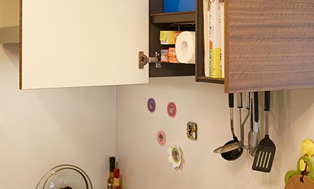 キッチンの棚にはペーパータオルやラップ類がすっきりと収まる。汚れが落ちやすい素材を使用した壁は掃除がしやすく、マグネットに対応しており、レシピを貼ったりすることもできて便利。