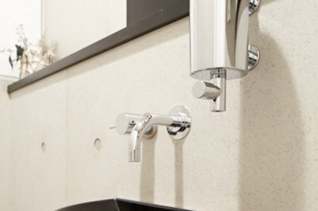 水栓類など金具はすべて同じメーカーで揃えた。トイレの壁に設置したソープのポンプディスペンサーは洗面所と同じタイプ。