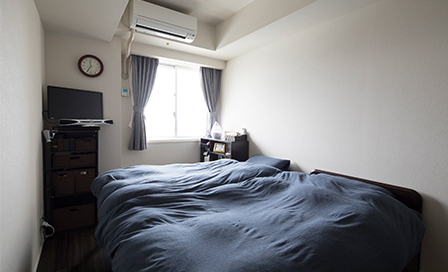 グレーとブラウン系のシックな雰囲気でまとめられた寝室。朝日がたっぷりと差し込む。