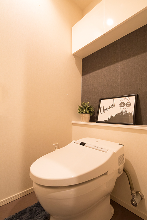 トイレは掃除のしやすいタンクレス型。棚の下のクロスを張り替え、絵や鉢を飾るコーナーに。