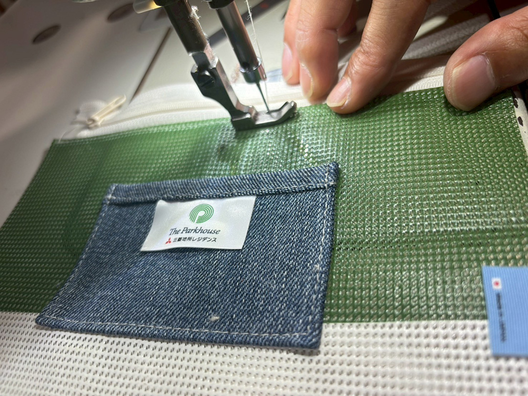 厚みのある横断幕素材を一針ずつ丁寧に縫い上げる