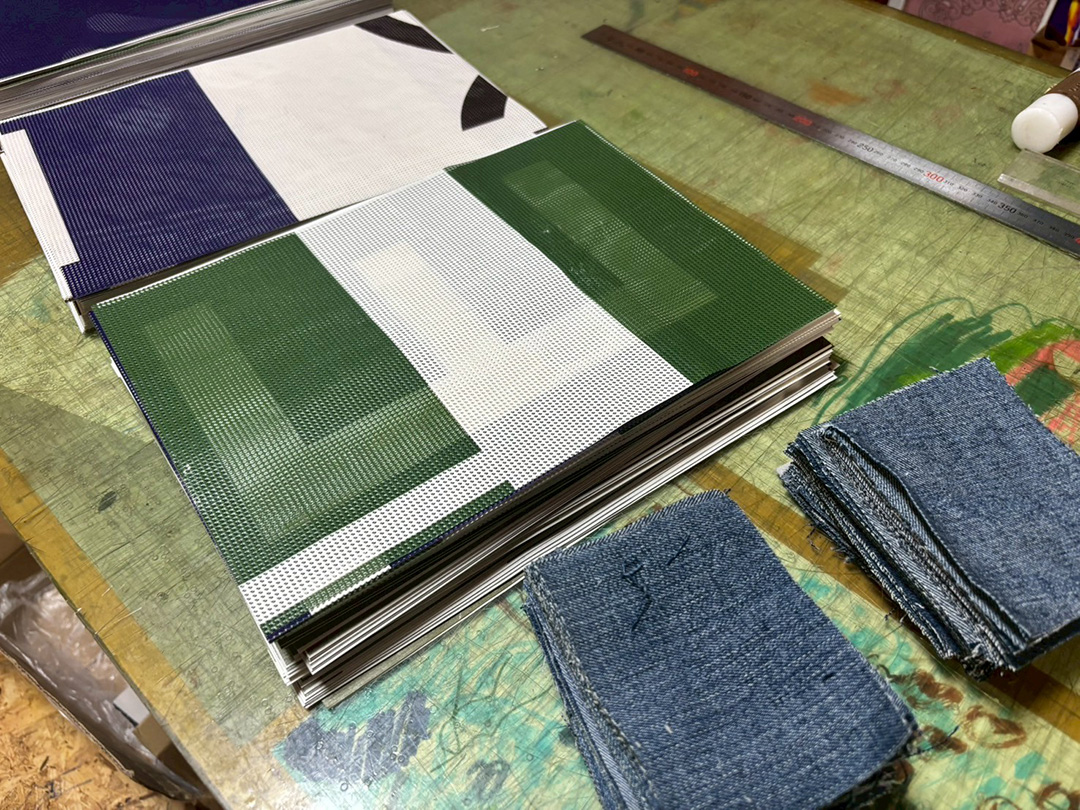 制作現場に並ぶ、切り分けられた横断幕とリサイクルデニム
