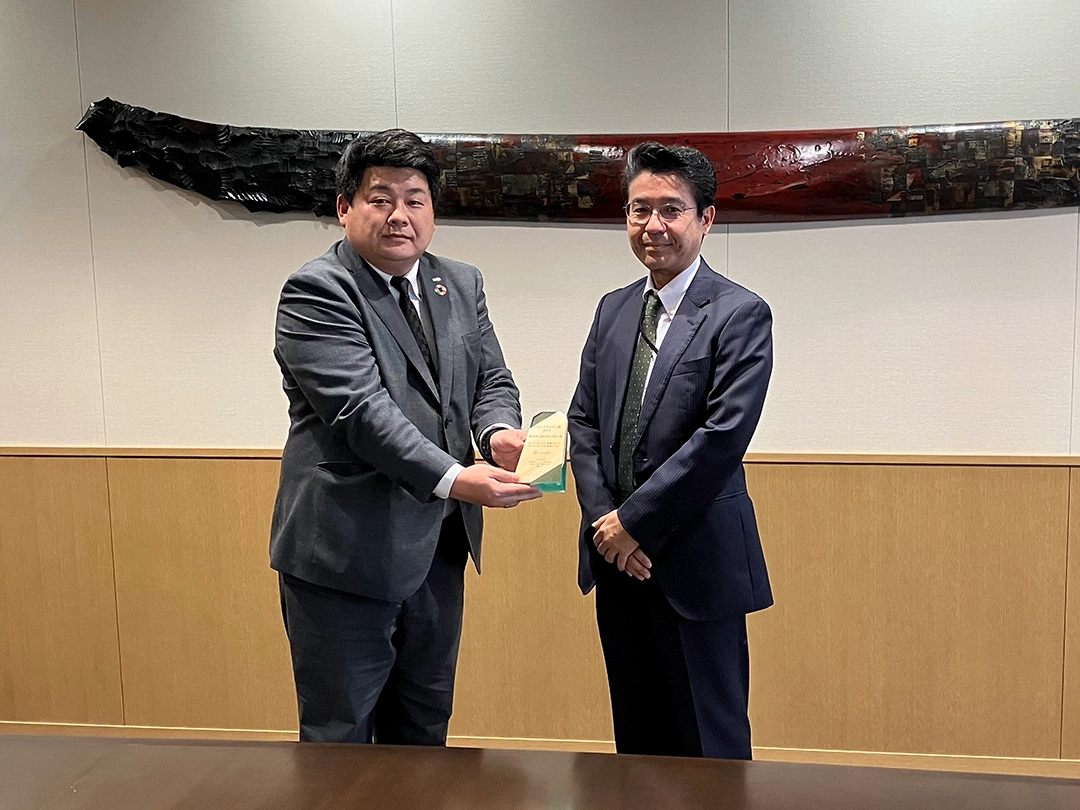 感謝の気持ちを込めて木製トロフィーをお渡しする様子