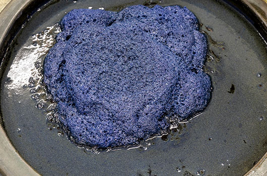 発酵によってできた泡が静かに揺れる藍甕（あいがめ）