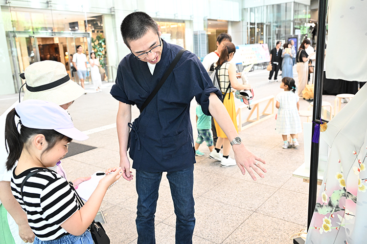 「手描友禅」職人・上仲氏の話しをメモを取りながら楽しむ様子