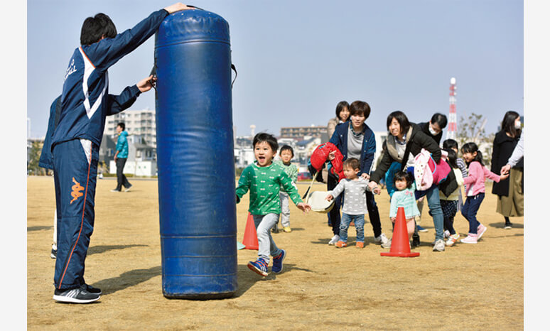 アメフト入門＆防災ゲームの様子。ちびっ子たちも初めてのタックルにトライ。