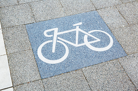 地面のタイルに描かれた自転車のサイン。街づくりに則した道路の特徴によって、3種類のデザインを使い分けている。