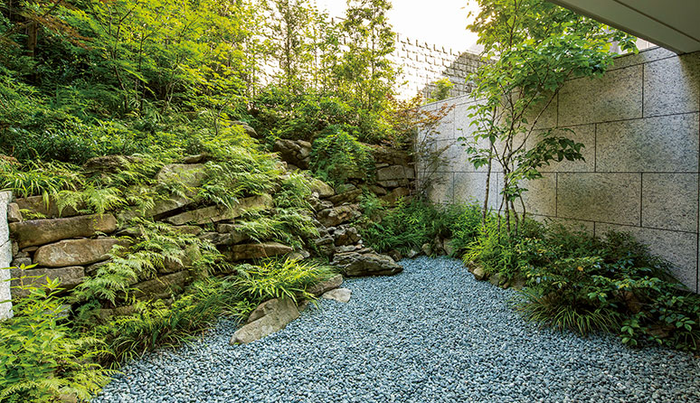 中庭→清流の庭 表面に亀甲模様が現れる相木石などを組み上げ、積層の合間を水が流れる「滝組」を創出。