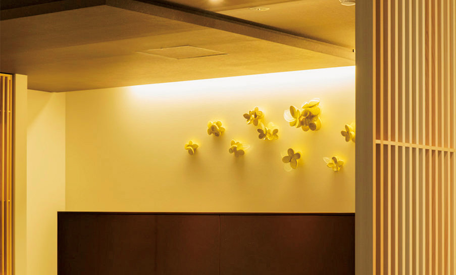コンシェルジュデスクの壁に､陶芸家･田嶋悦子氏の作品「FLOWERS」が彩りを添える。