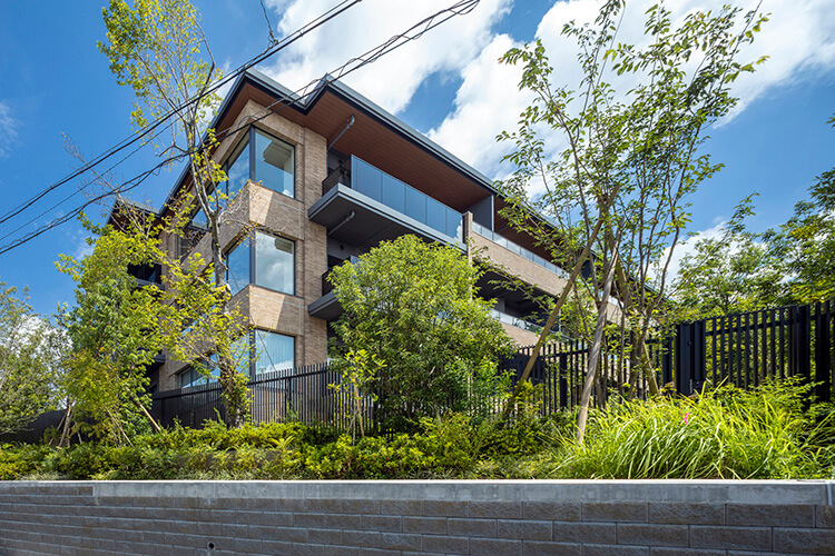 敷地境界には植栽を設け、建物を道路から離れた場所に建てることで圧迫感を低減
