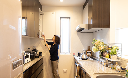 オプションで上下に設置した食器棚（写真左側）は、備え付けの吊り戸棚と色や素材を揃えたものに。