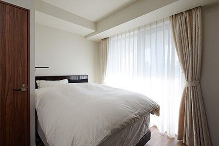 寝室も白、黒、ブラウン系ですっきりとまとめられている。カーテンもリビング・ダイニングとお揃い。