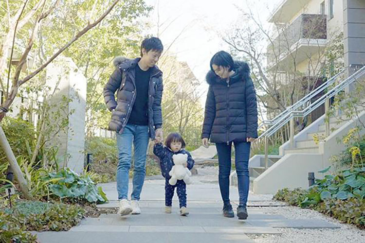 自然豊かな中庭で散歩する浅野さん家族
