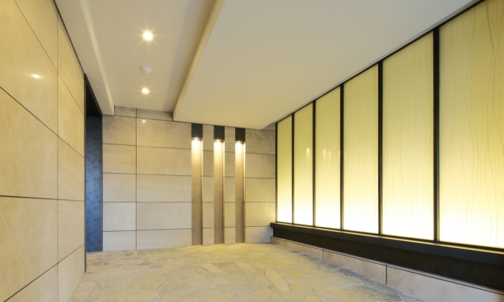 エントランスの床には、アースカラーのボーダータイルと自然石を乱貼りに。上質な雰囲気を醸し出す。